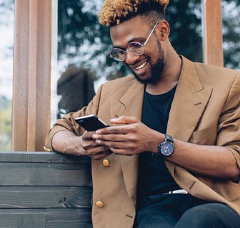 Man looking at phone on a bench