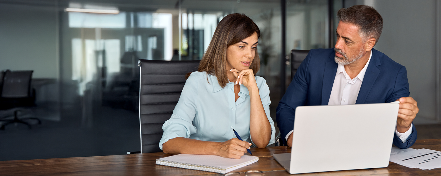 man and woman looking at computer