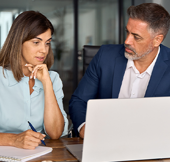 man and woman looking at computer