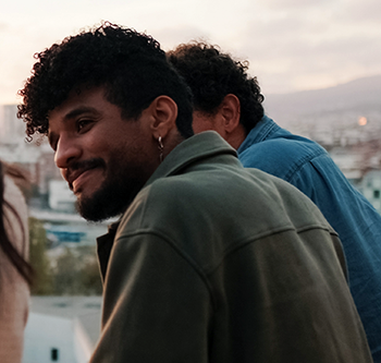 man smiling and looking at his friends