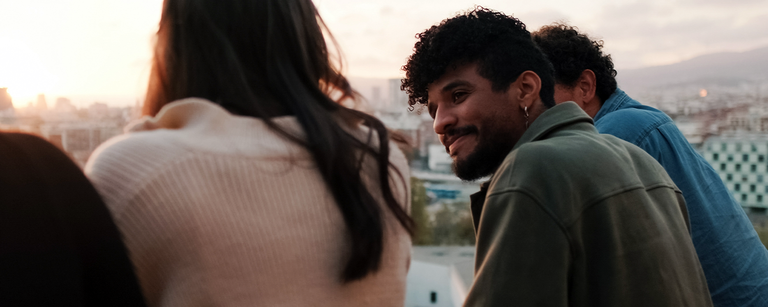 man smiling and looking at his friends