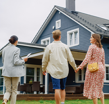 couple and realtor walking towards home