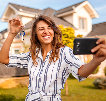 woman taking a selfie with her new house