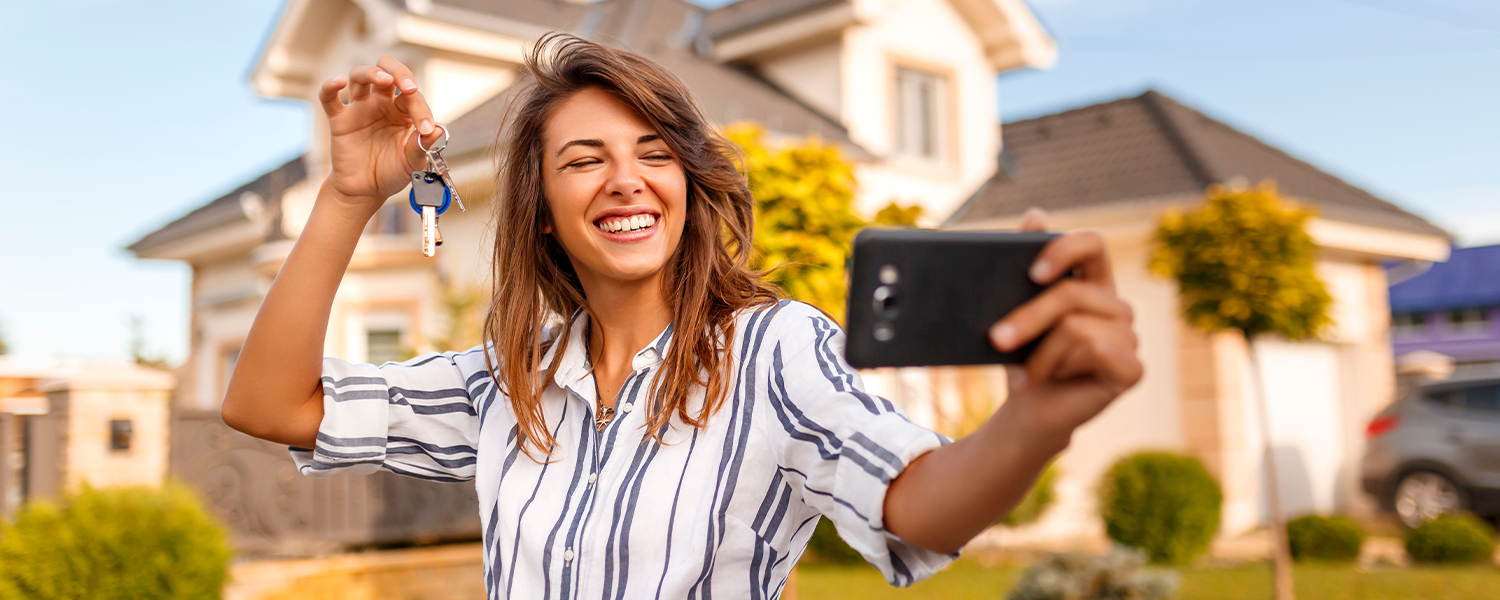 woman taking a selfie with her new house