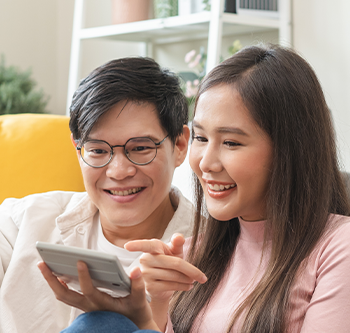man and woman looking at phone