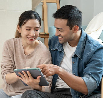 man and woman looking at tablet together