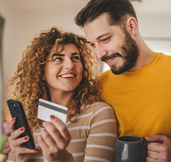 couple drinking coffee and looking at woman's phone