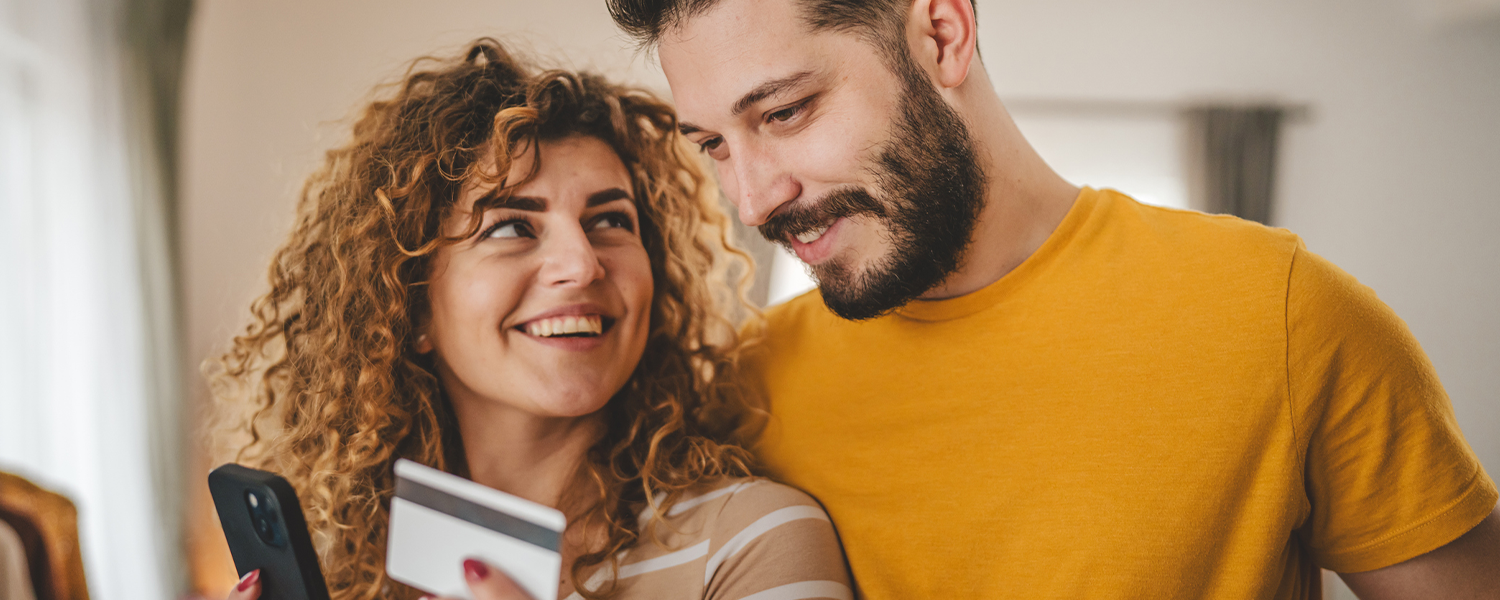 couple drinking coffee and looking at woman's phone