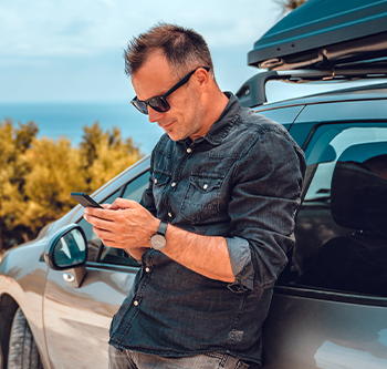 man leaning against his car