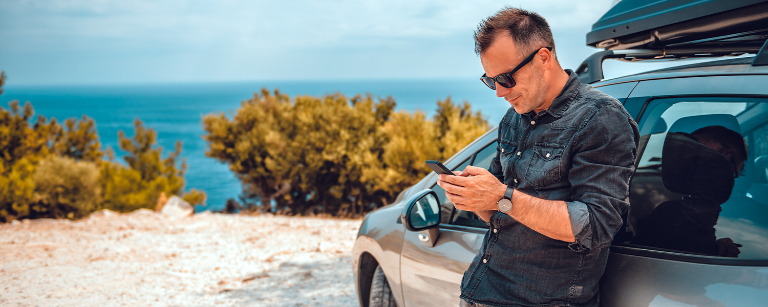 man leaning against his car