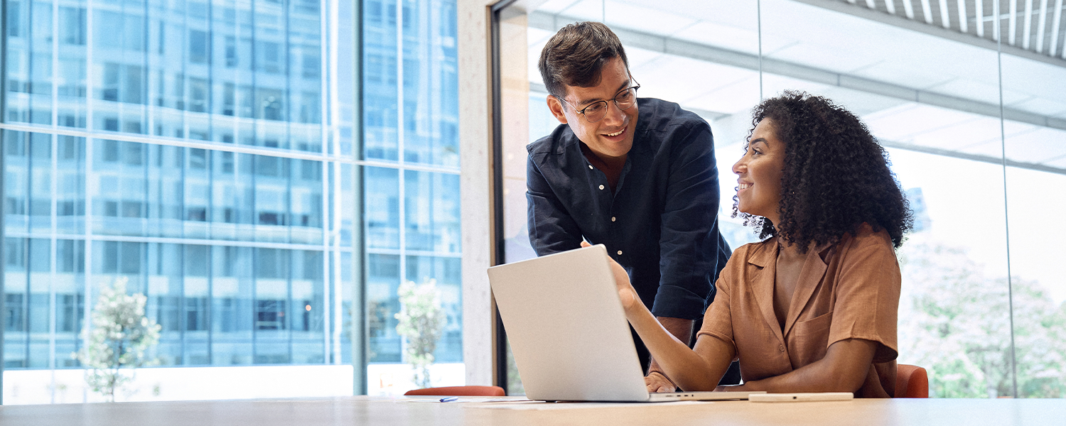 man and woman talking at a laptop