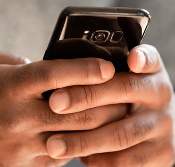 Close up of person's hands typing on their phone