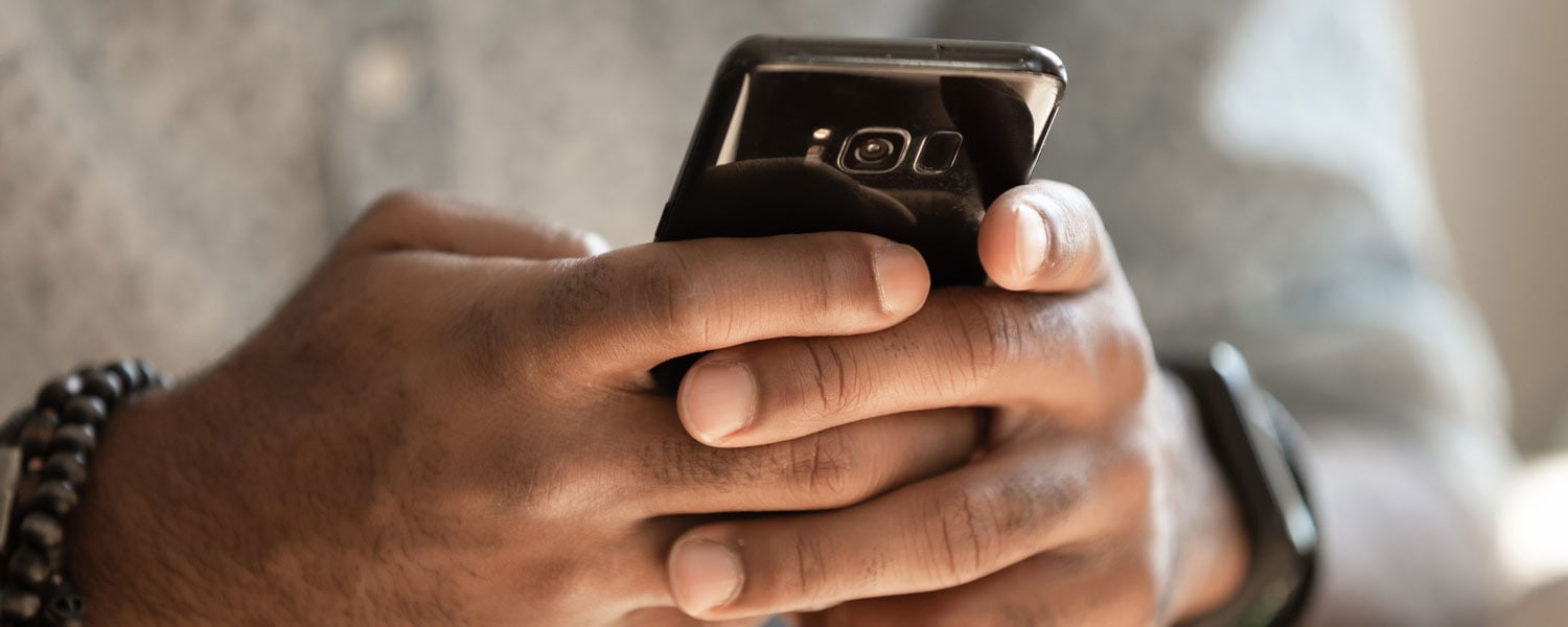 Close up of person's hands typing on their phone