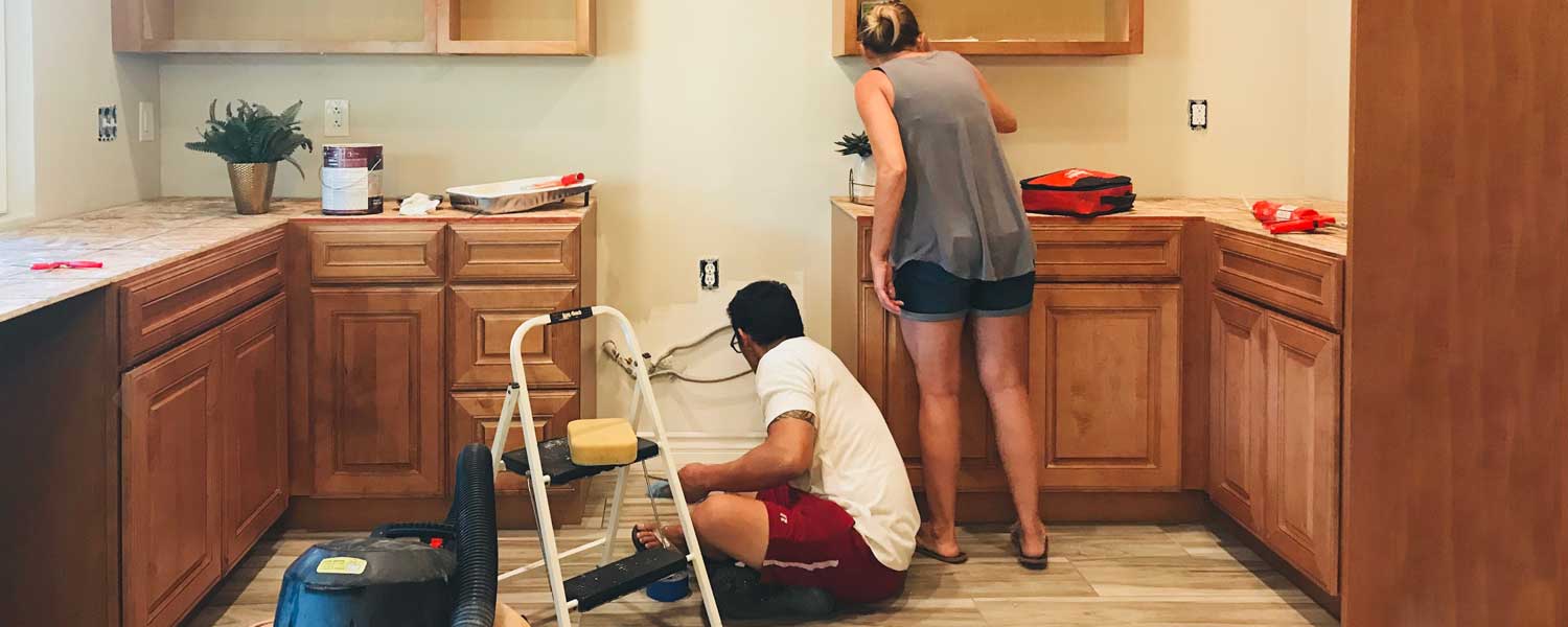 Woman and man painting their kitchen wall together