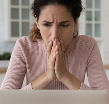 Woman in pink sweater looking stressed out