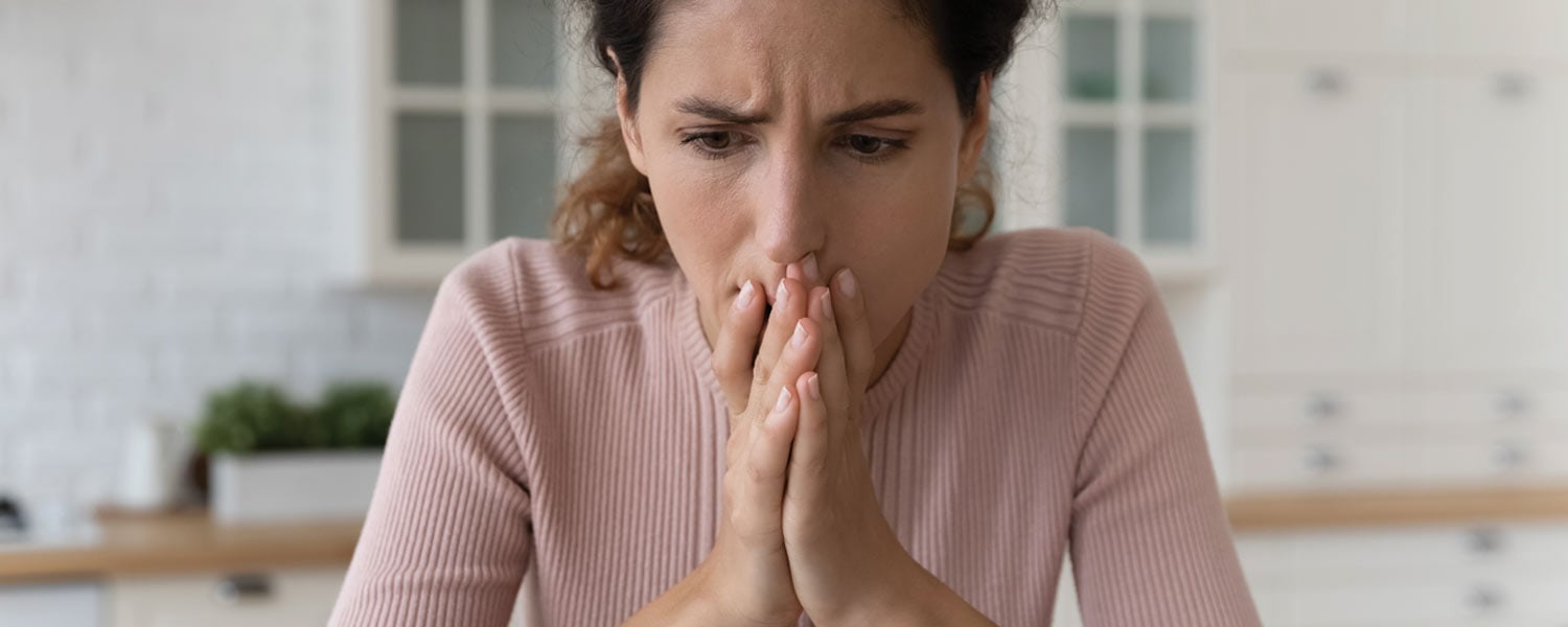 Woman in pink sweater looking stressed out