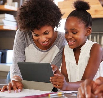 Woman and girl looking at a tablet together