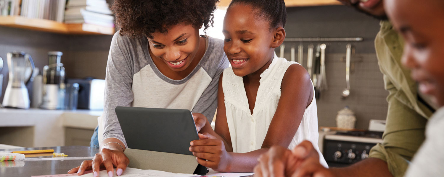 Woman and girl looking at a tablet together