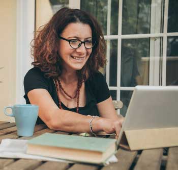 Woman smiling and typing on laptop