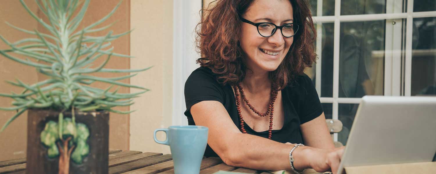 Woman smiling and typing on laptop