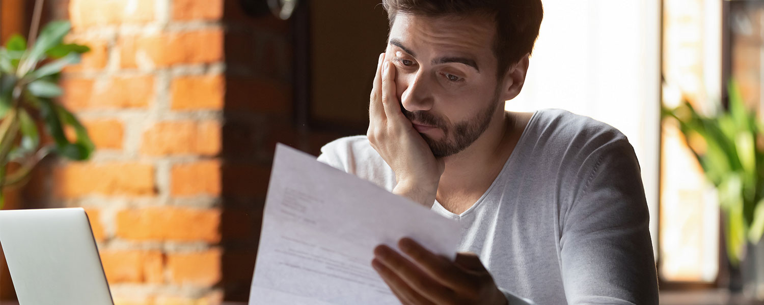 Man looking stressed and staring at a piece of paper