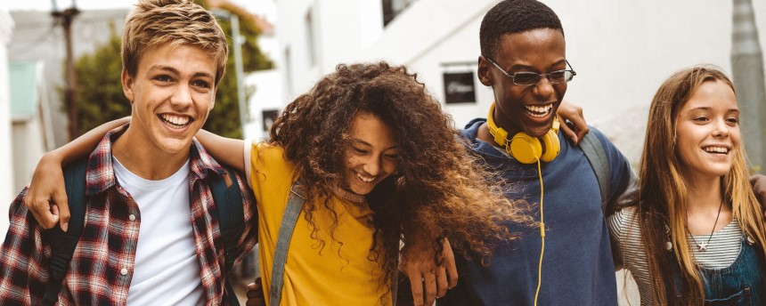 Three teenagers laughing and walking together