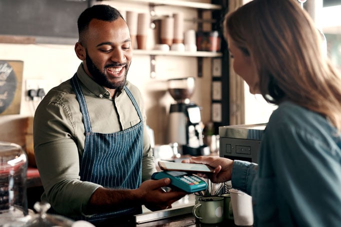 Woman using her phone to pay for a coffee