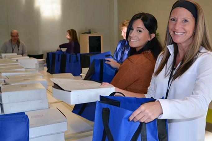 Two women packing donations into bags