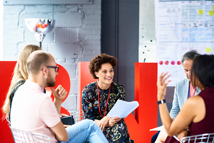 Woman sitting in a group holding a paper