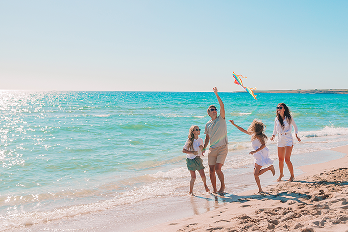 family playing at the beach
