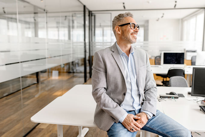 Man sitting on a desk and smiling