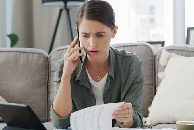 woman looking shocked on the phone