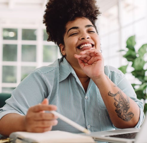 Woman smiling with a pencil in her hand