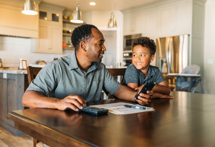 Father and Son sitting together with a calculator and phone