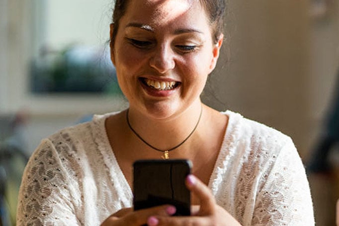 Woman smiling and texting on her phone