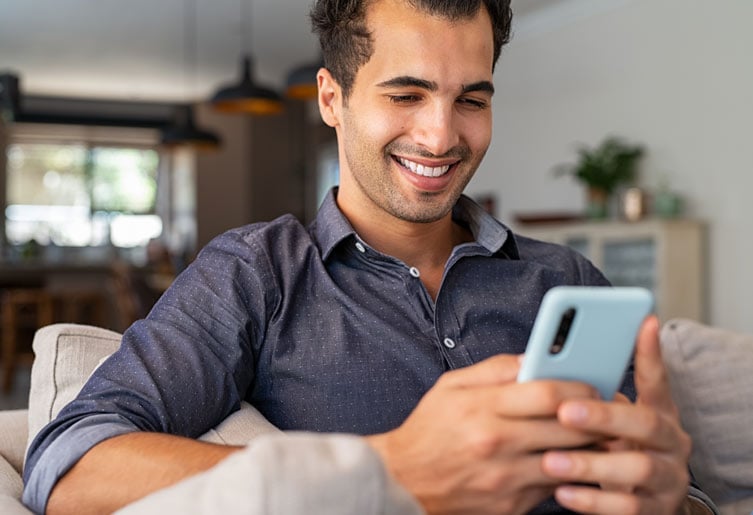 Man sitting on the couch using his phone