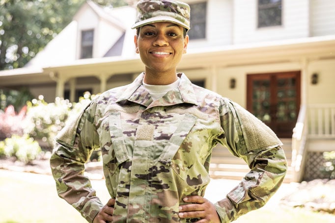 female soldier in front of house