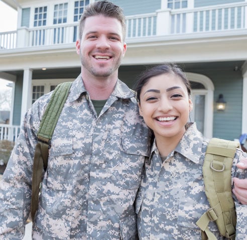 Military couple in front of house