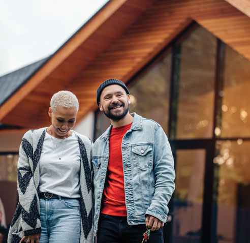 Couple standing outside of house with keys