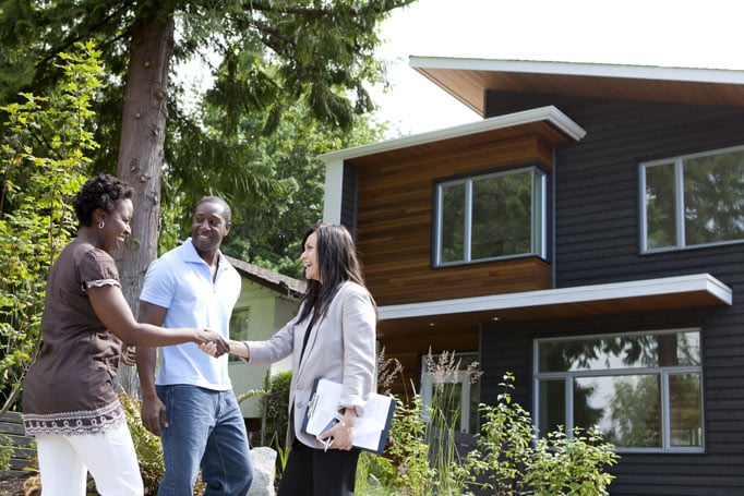 Homebuyers shaking hands with agent