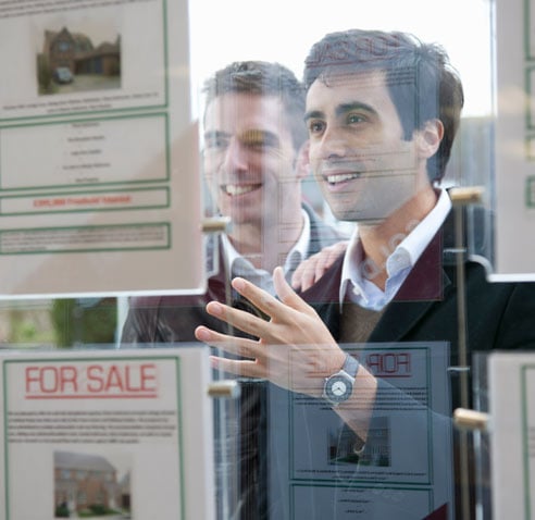 Two men looking at houses for sale