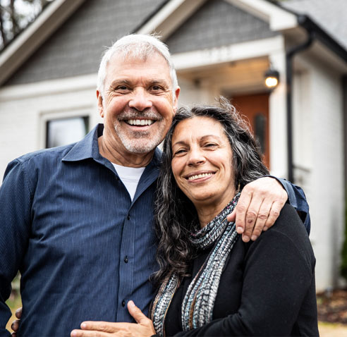 Couple standing outside their home