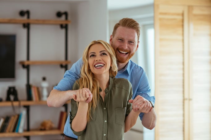 Couple holding hands inside their home