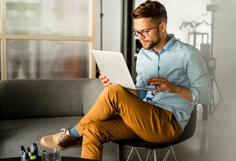 Man sitting in chair using a laptop