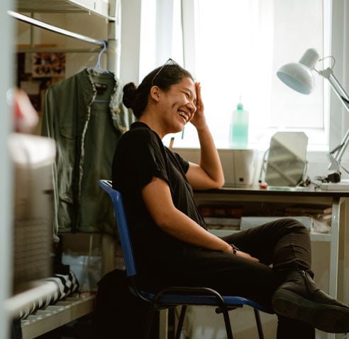 Woman laughing while leaning her head in her hand