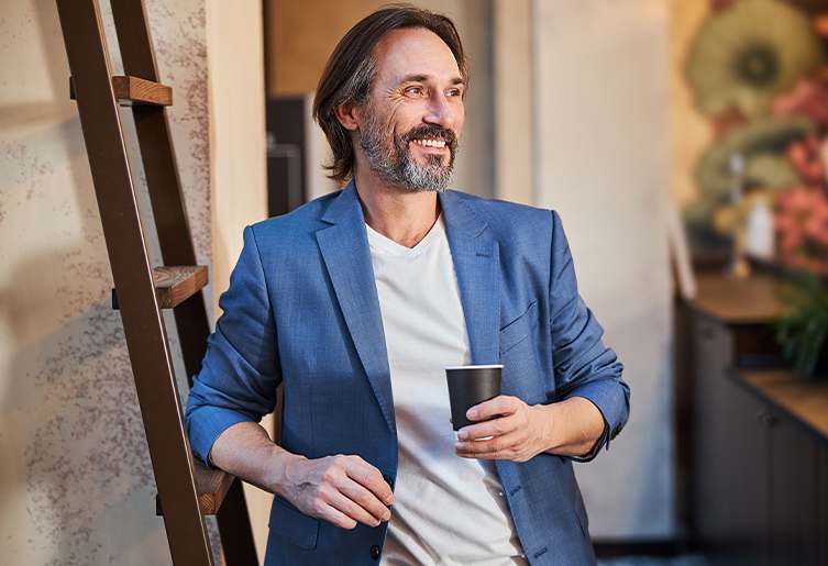 Man leaning against a ladder and smiling