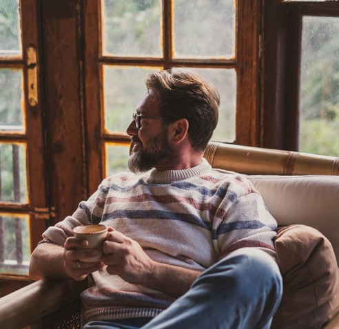 Man sitting on the couch with a cup of tea