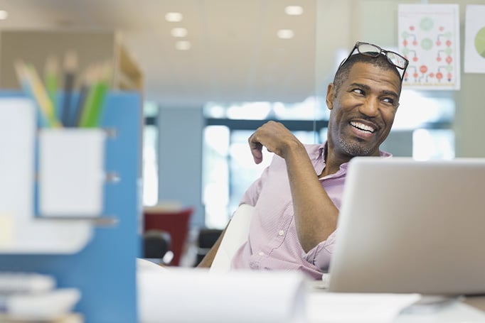 Man smiling over a laptop