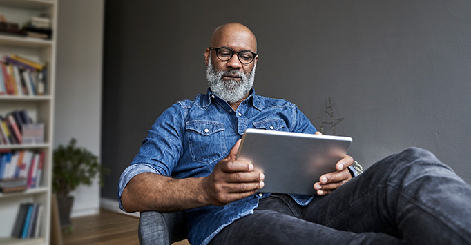 Man sitting down looking at a tablet