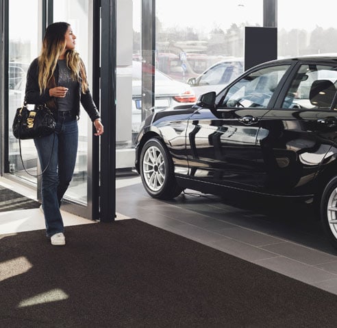 Woman walking into car dealership